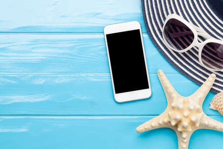 Travel and vacation concept. Trip accessories and items. Sun hat, sunglasses, smartphone and starfish. Top view flat lay with copy spaceの写真素材