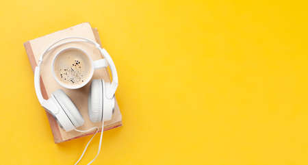 Coffee cup, book and headphones. Podcast or audiobook concept. Top view flat lay with copy spaceの写真素材