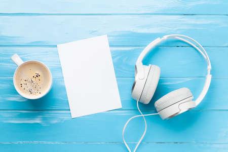 Headphones, coffee cup and blank paper. Top view flat lay with copy spaceの写真素材