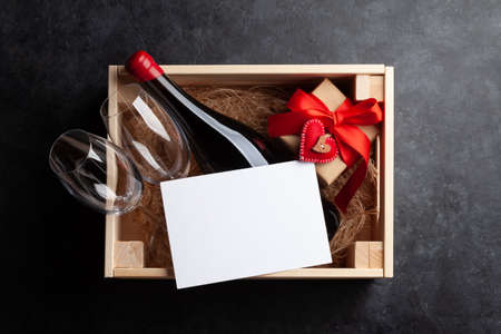 Valentines day gift box with red wine bottle. Top view flat lay with greeting card for your greetingsの写真素材