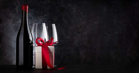 Valentines day gift box and red wine bottle. With space for your greetingsの写真素材
