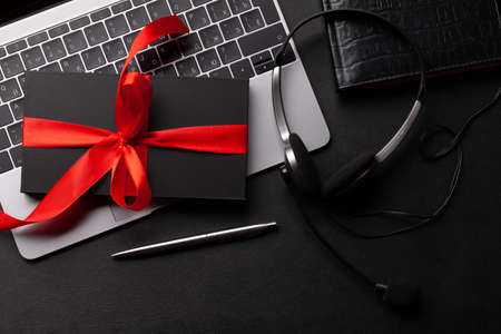 Gift box over laptop on office desk table. Top view flat lay with copy space. Online shopping conceptの写真素材