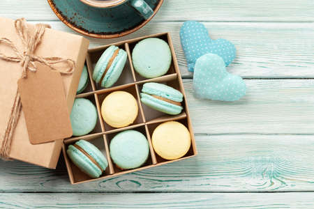Homemade macaroons in gift box and coffee cup. Top view flat lay with copy spaceの写真素材