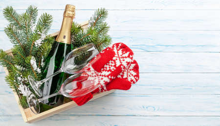 Christmas gift box with champagne bottle and mittens. Top view flat lay with space for your greetingsの写真素材