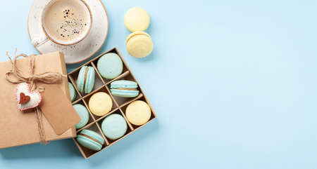 Homemade macaroons in gift box and coffee cup. Top view flat lay with copy spaceの写真素材