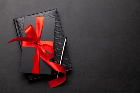 Gift box over notepad on office desk table. Top view flat lay with copy space. Online shopping or...
