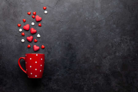 Coffee cup and heart shaped candy. Top view flat lay with copy space. Valentines day greeting card...
