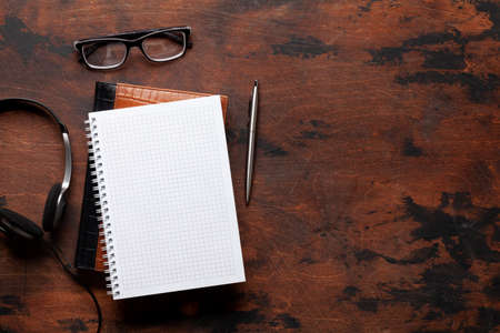 Blank notepad and headset. Top view flat lay with copy space