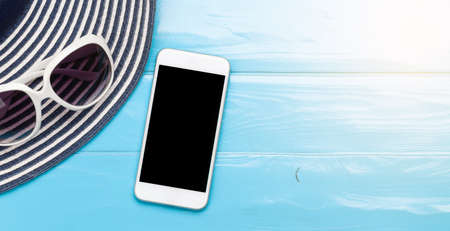 Travel and vacation concept. Trip accessories and items. Sun hat, sunglasses and smartphone. Top view flat lay with copy spaceの写真素材