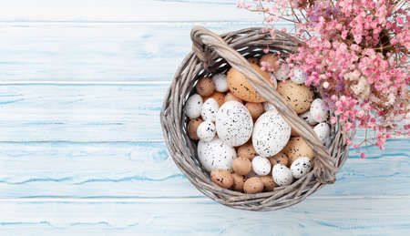 Easter greeting card with easter eggs and flowers. Top view flat lay with copy space