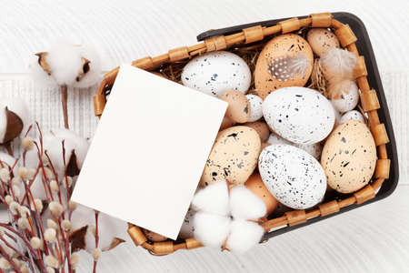 Easter greeting card with easter eggs and flowers. Top view flat lay with copy space