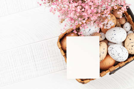 Easter greeting card with easter eggs and flowers. Top view flat lay with copy space