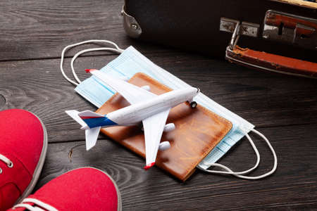 Travel and vacation concept. Luggage with trip items and clothes, airplane model over passport