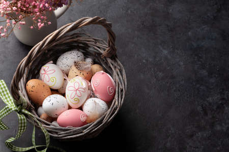 Easter greeting card with easter eggs and flowers. Top view flat lay with copy space