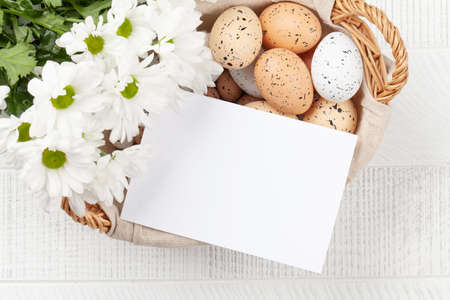 Easter greeting card, easter eggs and flowers. Top view flat lay with copy space