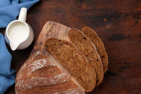 Sliced homemade bread and milk on wooden table. Flat lay with copy space