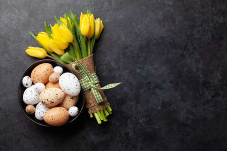 Easter greeting card with tulips and easter eggs. Top view flat lay with space for your greetingsの写真素材