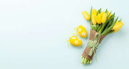 Easter greeting card with tulips and easter eggs. Top view flat lay with space for your greetingsの写真素材