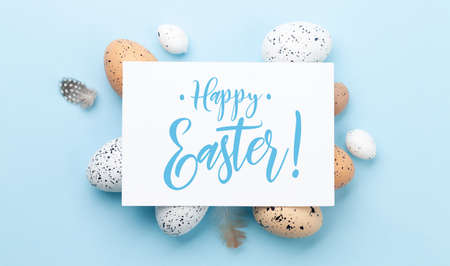 Easter greeting card over easter eggs. Top view flat lay with copy space