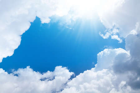 Blue sunny sky with clouds and copy space in center