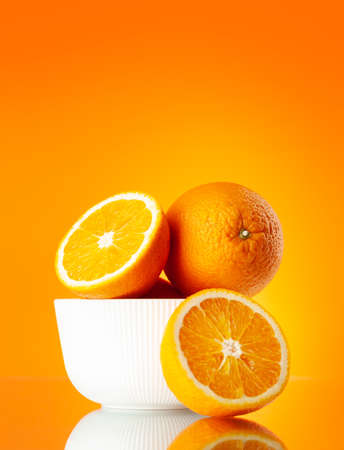 Fresh orange fruits over orange background with copy spaceの写真素材
