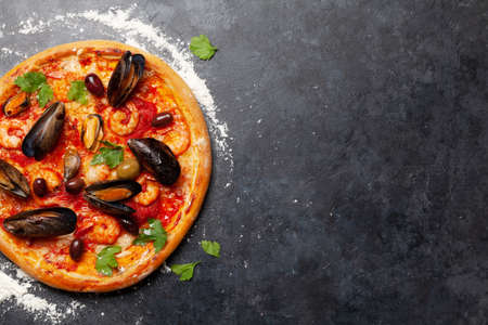 Italian food. Seafood pizza. Flat lay on stone table with copy spaceの写真素材