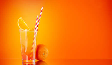 Tequila sunrise cocktail on orange background with copy spaceの写真素材