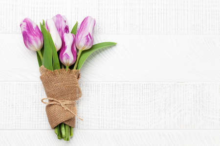 Colorful tulip bouquet on wooden table. Flat lay with copy spaceの写真素材