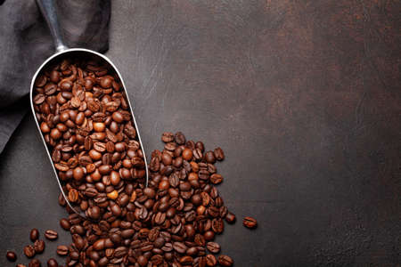 Roasted coffee beans in scoop. Flat lay on stone table with copy spaceの写真素材
