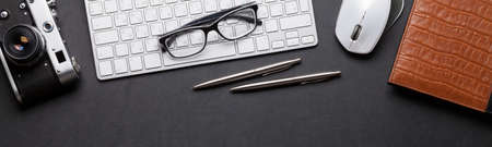 Office desk with photo camera, pc, notepad, glasses, pen and pencil. Flat lay with copy space
