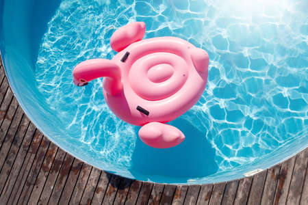 Pink flamingo inflatable ring in sunny pool. summer holidaysの写真素材