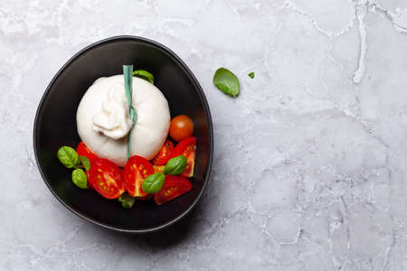 Burrata cheese, cherry tomatoes and basil. Italian food. Flat lay with copy spaceの写真素材