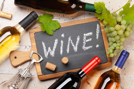 Various wine bottles, glasses and corkscrews on stone table. flat layの写真素材