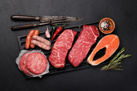Various raw meats and fish. Steaks, sausages, salmon and spices. flat layの写真素材