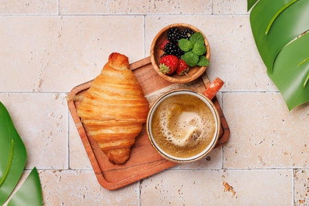 Coffee cup, berries and croissant. Flat lay with copy spaceの写真素材
