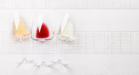White, rose and red wine glasses. Flat lay with copy spaceの写真素材