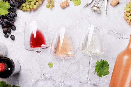 White, rose and red wine glasses and bottles. flat layの写真素材