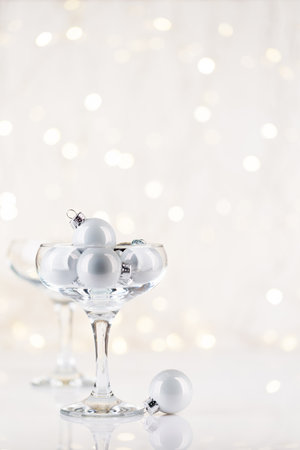 Champagne glasses with xmas decor in front of Christmas lights bokeh with copy space for your greetings