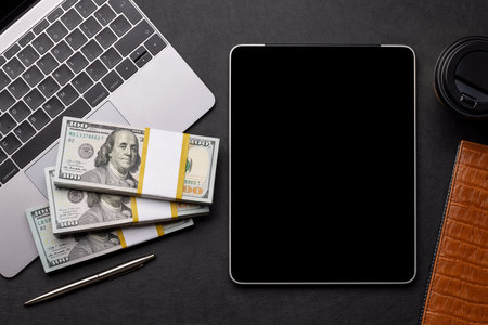 Office desk table with tablet, laptop computer, cash and cup of coffee. Top view with copy space. flat layの写真素材