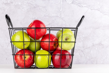 Red and green garden apples in basket. With copy spaceの写真素材