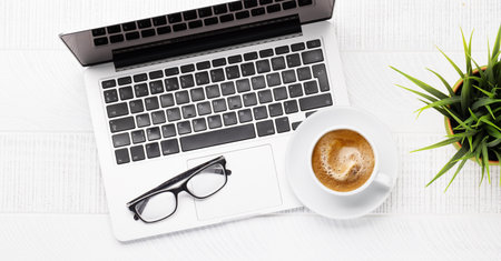 Office desk table with laptop computer, cup of coffee and supplies. top view. flat layの写真素材