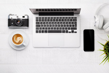 Office desk table with laptop computer, cup of coffee and supplies. top view. flat lay