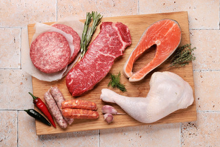 Various raw meats and fish. Steaks, sausages, salmon, chicken and spices. flat layの写真素材