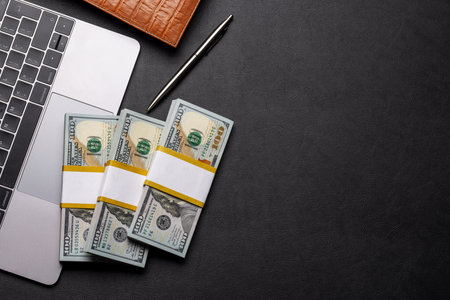 Office desk with cash money on laptop. Flat lay with copy spaceの写真素材
