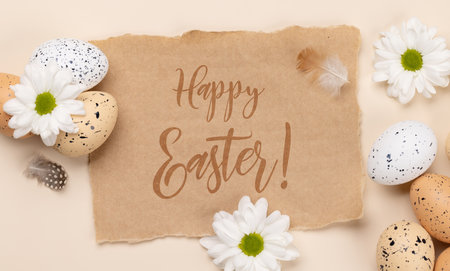 Easter eggs and flowers on a beige background with easter greetings. flat lay