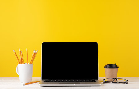 Laptop with blank screen for your message, app or web and coffee cup. Computer with white displayの写真素材