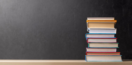 Stack of books on desk with chalkboard and space for creativityの写真素材
