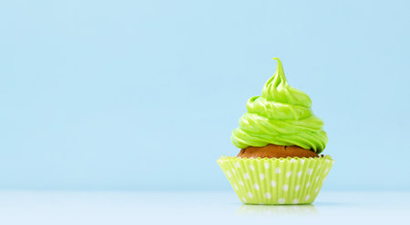 Green cream cupcake on blue background with copy spaceの写真素材