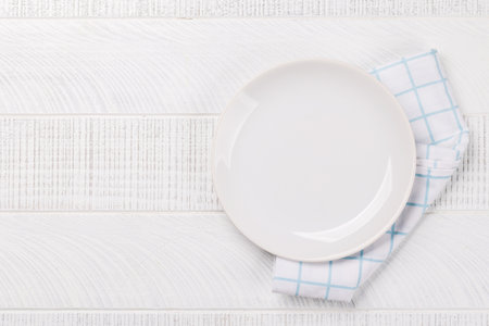 Top-down view of an empty plate mockup, perfect for showcasing a meal. Flat lay on wooden tableの写真素材