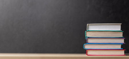 Stack of books on desk with chalkboard and space for creativityの写真素材